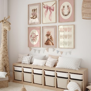 May include: A nursery wall decor set featuring six framed prints with a cowgirl theme. The prints include images of cowboy boots, a pink bow, a horseshoe, a cowgirl hat, a girl on a horse, and the word "HOWDY". The color palette is soft pink and beige.