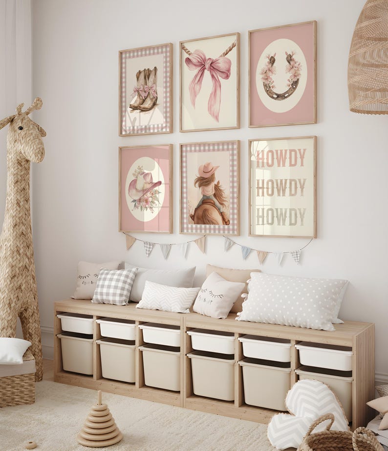 May include: A nursery wall decor set featuring six framed prints with a cowgirl theme. The prints include images of cowboy boots, a pink bow, a horseshoe, a cowgirl hat, a girl on a horse, and the word "HOWDY". The color palette is soft pink and beige.