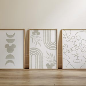 Könnte beinhalten: Drei gerahmte Wandbilder mit salbeigrünen Motiven auf weißem Hintergrund. Der erste Druck zeigt Mondphasen und eine Maus-Silhouette. Der zweite zeigt Bögen und Blätter. Der dritte Druck besteht aus einer durchgehenden Linienzeichnung einer Maus.