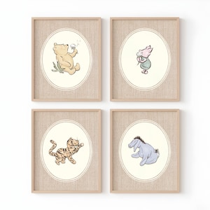 May include: A set of four framed wall art prints featuring illustrations of Winnie the Pooh, Piglet, Tigger, and Eeyore. Each print is housed in a light wood frame with a textured mount and an oval border surrounding the character artwork.