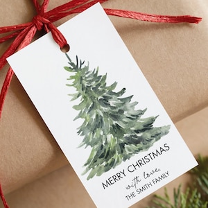 Könnte beinhalten: Ein Geschenk, das mit einem roten Band und einem weißen Anhänger verpackt ist. Der Anhänger zeigt eine Aquarellillustration eines grünen Weihnachtsbaums und den Text "MERRY CHRISTMAS with love, THE SMITH FAMILY."