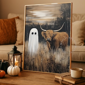 May include: Framed art print featuring a white ghost and a Highland cow in a field. The artwork has a rustic, autumnal theme with a muted color palette of browns, tans, and blacks. The ghost has two black eyes, and the cow has long, curved horns.