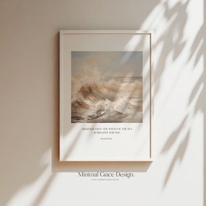 Könnte beinhalten: Ein gerahmter Druck mit einem Gemälde von Ozeanwellen, die an die Küste krachen. Der Druck enthält den Text "Greater than the waves of the sea is His love for you. Psalm 93:4". Der Druck ist auf weißem Hintergrund und hat einen weißen Rahmen. Der Text "Minimal Grace Design." befindet sich unterhalb des Rahmens.