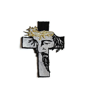 Könnte beinhalten: Ein gestickter Bügelaufkleber mit einem silbernen und schwarzen Kreuz mit einer Darstellung von Jesus Christus, der eine Dornenkrone trägt.