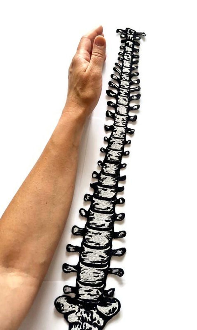 Puede incluir: Parche de columna vertebral bordado en blanco y negro. El parche es una representaci&oacute;n anat&oacute;mica detallada de la columna vertebral humana. El parche mide aproximadamente 30 cm de largo.