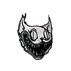 Puede incluir: Parche bordado en blanco y negro de un gato con una amplia sonrisa de dientes y grandes ojos redondos.