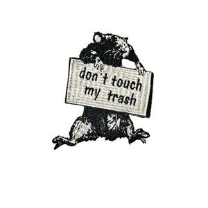 May include: Black and white embroidered patch of a rat holding a sign that says "don't touch my trash".