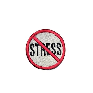 Könnte beinhalten: Runder, gestickter Aufnäher mit rotem Rand und roter Diagonallinie durch das Wort "STRESS" in Schwarz. Der Hintergrund des Aufnähers ist weiß.