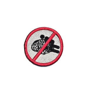 Op de afbeelding: Geborduurde patch met een rode rand met een doorgestreept brein en een figuur. De patch heeft een grijze achtergrond en zwarte en rode details. Het ontwerp suggereert een verbodsthema.
