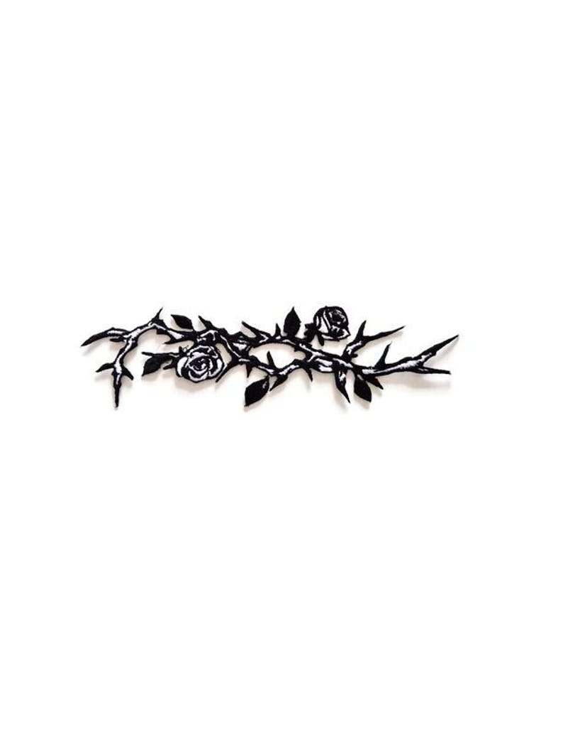 May include: Black metal floral design featuring roses, thorns, and leaves against a white background. The decorative piece is a stylized representation of a rose branch.