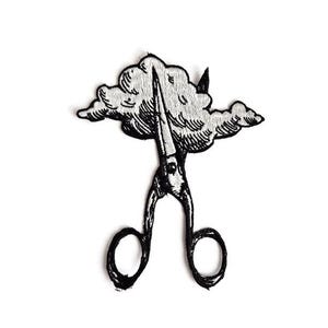 May include: Black and white embroidered patch featuring a pair of scissors cutting through a cloud. The scissors are detailed with a vintage design, and the cloud has a textured, fluffy appearance. The patch is likely for clothing or accessories.