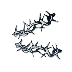 May include: Two black embroidered patches of thorny branches with white stitching.