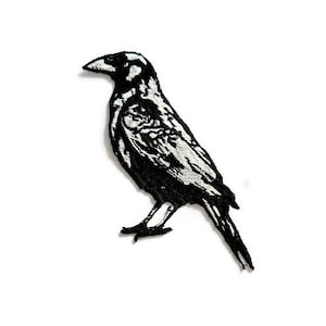 May include: Black and white embroidered iron-on patch of a crow with its wings folded.