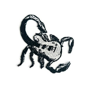 May include: Black embroidered scorpion patch with a white guitar-shaped body.