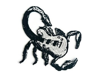 Könnte beinhalten: Schwarzer gestickter Skorpion-Patch mit einem weißen, gitarrenförmigen Körper.