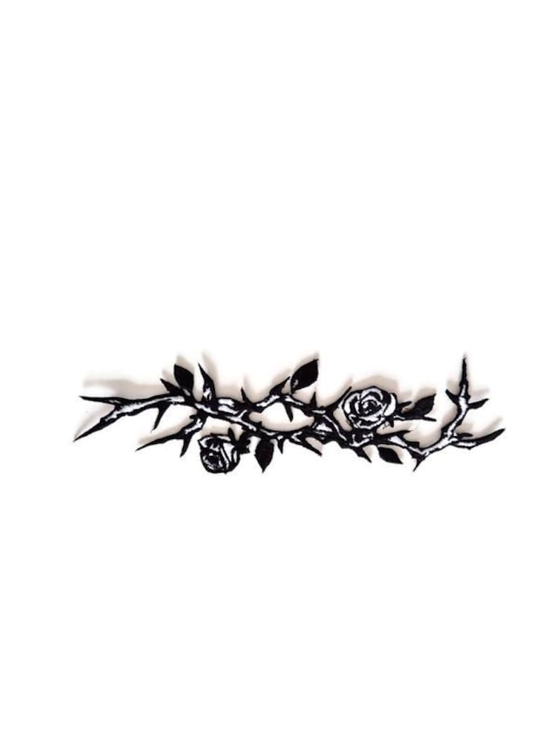 K&ouml;nnte beinhalten: Ein schwarz-wei&szlig;es Blumendesign mit Rosen und Dornen. Das Design ist eine stilisierte Illustration eines Rosenzweigs mit Bl&auml;ttern und Dornen. Die Rosen sind in voller Bl&uuml;te und die Dornen sind spitz.