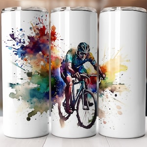 May include: A white stainless steel tumbler featuring a colourful watercolour design of a cyclist riding a bicycle. The design incorporates splashes of red, orange, yellow, green, blue and purple.