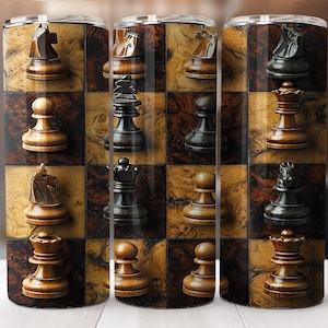 May include: A set of three stainless steel tumblers with a chessboard design featuring black and brown wooden chess pieces. The tumblers are arranged in a row on a white surface.