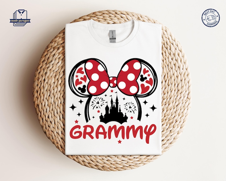 May include: White t-shirt with a red and black Mickey Mouse ears design and the word "GRAMMY" printed on the front. The ears have red polka dots and the design includes a silhouette of Cinderella's castle.