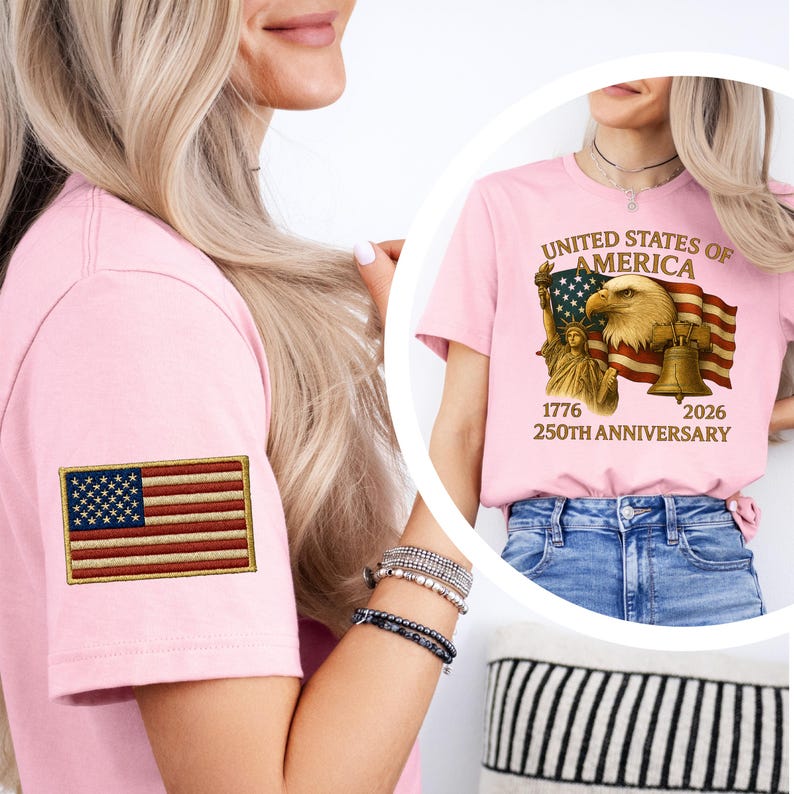 Puede incluir: Una camiseta rosa claro con una bandera americana bordada en la manga. La camiseta tambi&eacute;n muestra un gr&aacute;fico con el texto "United States of America" y las fechas "1776-2026 250th Anniversary" con un &aacute;guila, una bandera, la Campana de la Libertad y la Estatua de la Libertad.