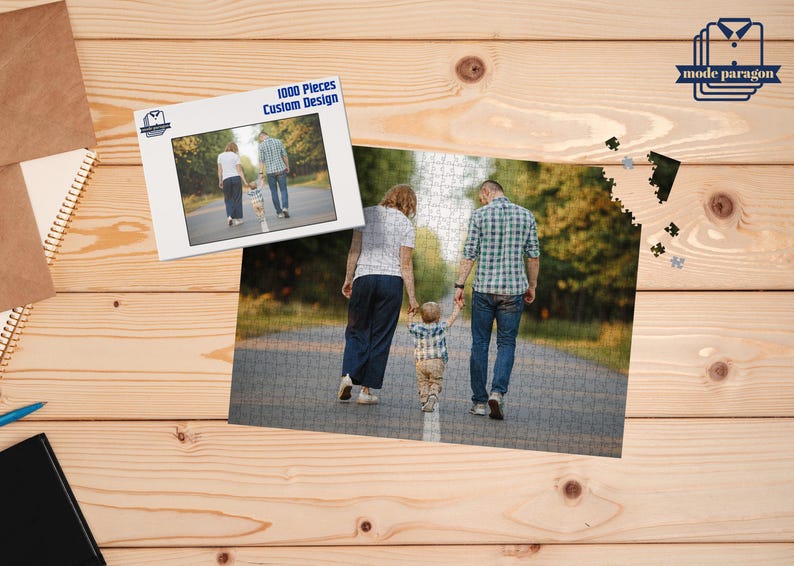May include: A custom design 1000-piece jigsaw puzzle featuring a family walking down a path. The puzzle is partially assembled, with a smaller image of the puzzle on a white background. The image is on a wooden surface.
