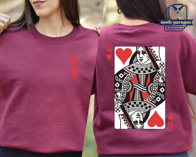May include: A maroon t-shirt with a red queen of hearts playing card design on the back. The front of the shirt has a small red queen of hearts symbol.