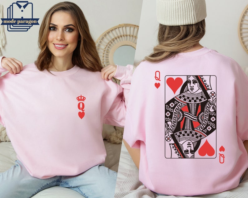 May include: Pink sweatshirt with a red queen of hearts playing card graphic on the back and a small red queen of hearts graphic on the front.