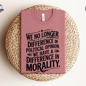 May include: A pink t-shirt with black text that reads "We no longer have a difference in political opinion. We have a difference in morality."