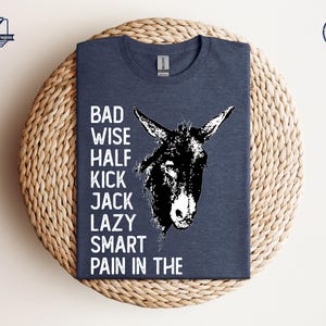 May include: A dark blue t-shirt with a white donkey illustration and the text "BAD WISE HALF KICK JACK LAZY SMART PAIN IN THE".