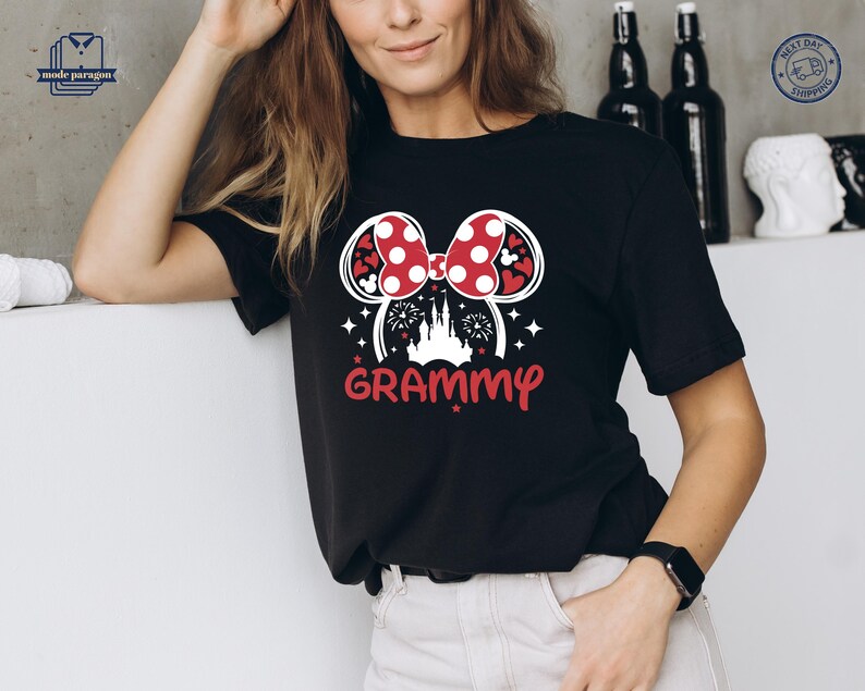 May include: Black t-shirt with a white graphic of a red and white Minnie Mouse bow with a castle and fireworks in the center. The text "GRAMMY" is below the graphic.