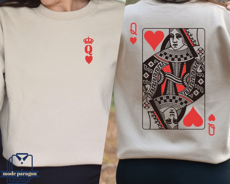 May include: Two cream colored sweatshirts with a red queen of hearts playing card design. One sweatshirt has a simple red queen of hearts symbol with a crown. The other sweatshirt has a full playing card design with a queen of hearts and the text "Q" on the card.