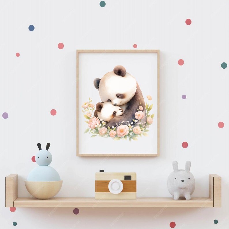 May include: A framed print of a mother panda and her baby panda hugging each other. The pandas are surrounded by pink flowers and green leaves. The print is on a white background and is framed in a light brown frame.