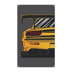 Peut inclure: Une voiture de sport jaune avec un aileron arrière noir et des feux arrière rouges. La voiture est de dos et est garée sur un fond gris.