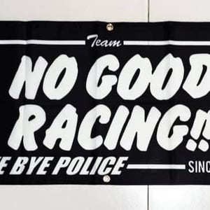 May include: Black and white banner with the text "Team No Good Racing! Bye Bye Police Since 1985". The banner has two white hand gestures pointing to the right.