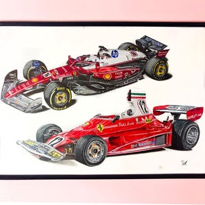 May include: Framed artwork featuring two Formula 1 race cars. The top car is red and white with sponsor logos. The bottom car is a classic red Ferrari with the number 12. The artwork is in a black frame.