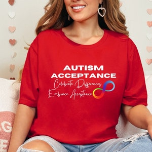May include: Red t-shirt with the text "AUTISM ACCEPTANCE Celebrate Differences Embrace Acceptance" and a rainbow infinity symbol.