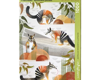 Puede incluir: Un rompecabezas de 1000 piezas con una ilustración colorida de tres numbats, un pequeño marsupial nativo de Australia Occidental. La caja del rompecabezas tiene un fondo verde con el texto "Numbat Myrmecobius fasciatus" y "50 x 70 cm - 19.7 x 27.5 in". La esquina inferior derecha de la caja tiene el texto "maddytaylor AUSTRALIAN DESIGNER & ILLUSTRATOR".