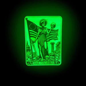 May include: A rectangular, glowing green graphic featuring a skeletal figure holding a skull and an American flag. The figure stands amidst skulls, with the text "HAIL COLUMBIA" at the bottom. The background is black.