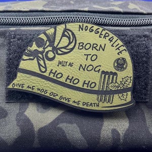May include: A green and black patch with a skull and the text "Nogger4Life Born To Nog Jolly AF Ho Ho Ho Give Me Nog Or Give Me Death".