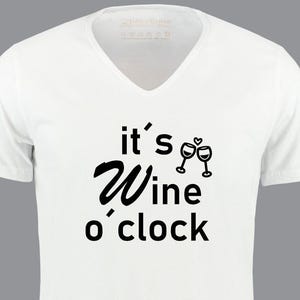 Könnte beinhalten: Weißes V-Ausschnitt-T-Shirt mit schwarzem Text "it's wine o'clock" und einer Grafik von zwei Weingläsern, die anstoßen.
