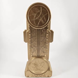 May include: A gold-colored 3D printed replica of the Eye of Agamotto from the Marvel Cinematic Universe. The Eye of Agamotto is a mystical artifact that is said to be able to control time and space.