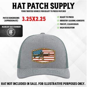 Op de afbeelding: Grijze truckerpet met een patch met een Amerikaanse vlag en een geweer. De afmetingen van de patch zijn ongeveer 8,26 x 5,72 cm. De pet heeft een mesh achterkant en de tekst "HAT PATCH SUPPLY" staat bovenaan.