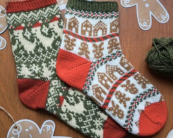 May include: Two knitted Christmas socks with festive patterns. One sock features a green and cream design, while the other showcases gingerbread houses and men. Both socks have red heels, toes, and cuffs. The socks are displayed on a wooden surface with gingerbread cutouts.
