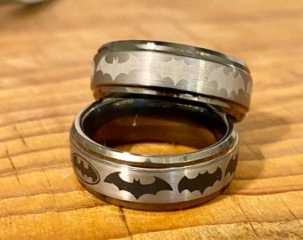 Tungsten Carbide superhero bat inspired ring, outside wrap around various symbols through the years.