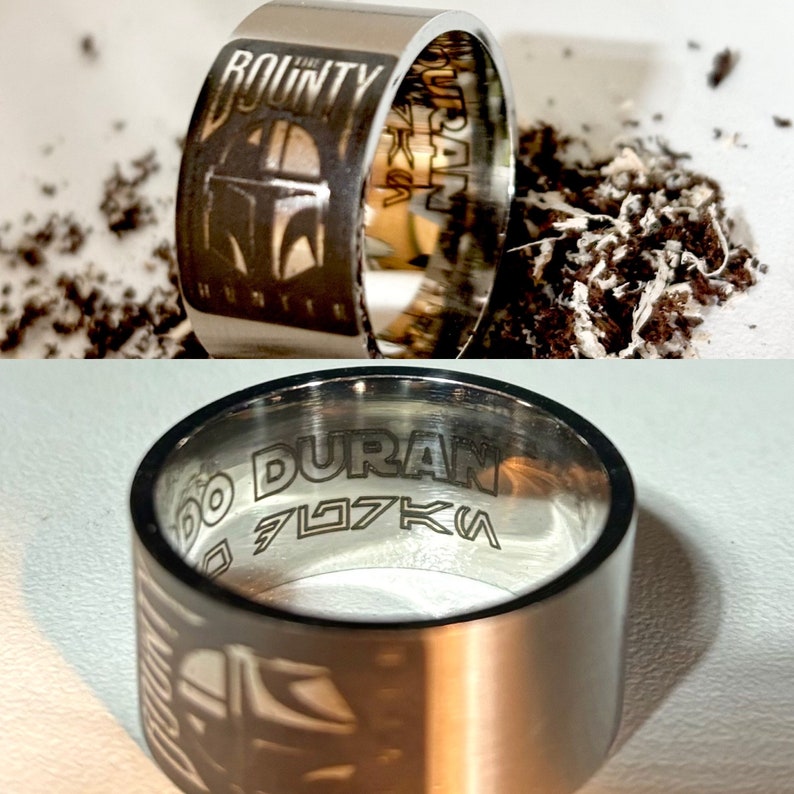 Pu&ograve; includere: Un anello d'argento con le parole "The Bounty Hunter" e "DURAN" incise. L'anello presenta anche un'immagine stilizzata di un elmetto mandaloriano.