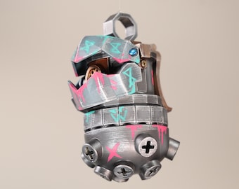 May include: A silver and gray 3D printed ornament with pink and blue paint accents. The ornament has a detailed design with screws and a small opening at the top.