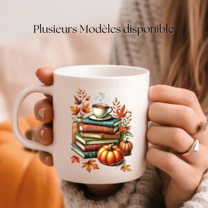 Peut inclure: Mug en céramique blanche avec une illustration colorée d'une pile de livres, une tasse de café et des citrouilles. Le texte "Plusieurs Modèles disponible" est imprimé sur le mug.