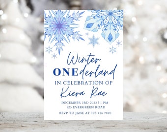 May include: A blue and white winter wonderland themed invitation for a first birthday party. The invitation features snowflakes and the text "Winter ONEderland" in celebration of Kiera Rae. The party is on 3rd December 2023 at 1 PM at 123 Evergreen Road. RSVP to Jane at 123 456 7890.