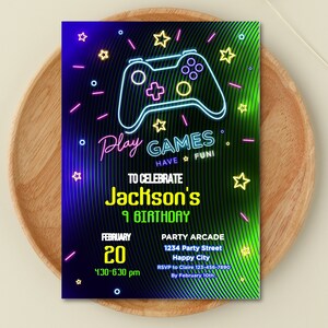 Puede incluir: Una invitación a una fiesta de cumpleaños de color verde neón, azul y rosa con un gráfico de mando de videojuego verde neón. El texto dice "Juega a juegos ¡Diviértete! Para celebrar el 9º cumpleaños de Jackson. 20 de febrero, 16:30-18:30. Arcade de la fiesta 1234 Party Street Happy City RSVP a Claire 123-456-7890 Antes del 10 de febrero."