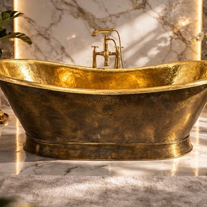 Può includere: Una vasca da bagno indipendente in metallo martellato con interno dorato ed esterno bronzo. La vasca ovale è collocata in un bagno con pavimento in marmo. Un rubinetto dorato e candele esaltano l'atmosfera da spa. Dimensioni: circa 180 cm di lunghezza.